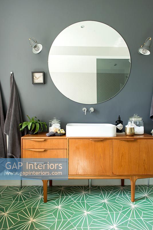 Buffet vintage avec lavabo dans salle de bain moderne avec sol vert clair