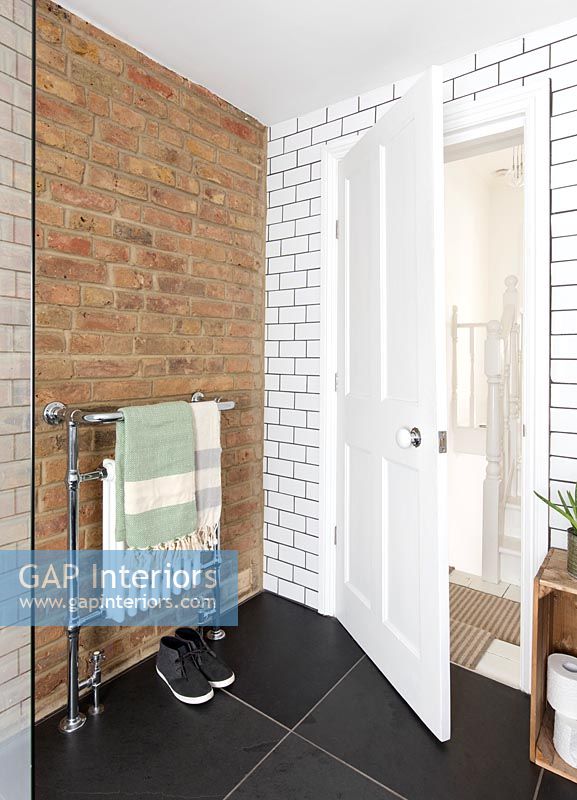 Mur de briques apparentes et carrelage blanc de style brique dans une salle de bains moderne