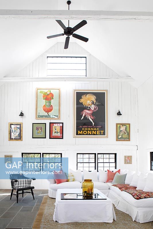 Affichage d'œuvres d'art colorées et ventilateur de plafond dans le salon de campagne moderne