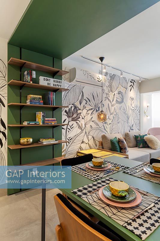Cadre en bois vert avec étagères intégrées, table à manger et vue sur le salon