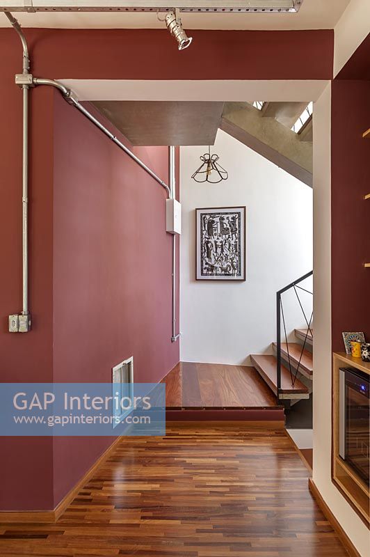 Couloir et escaliers avec des murs peints en rouge foncé