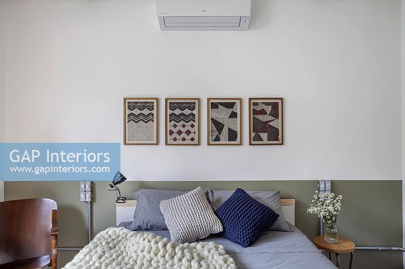 Chambre moderne avec groupe de peintures au-dessus du lit