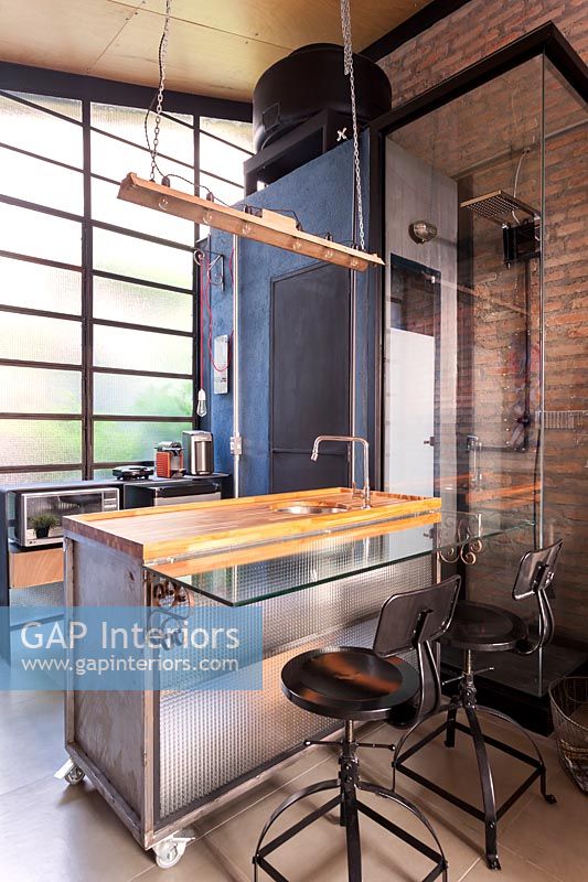 Cuisine industrielle moderne avec mur de briques apparentes et cabine de douche
