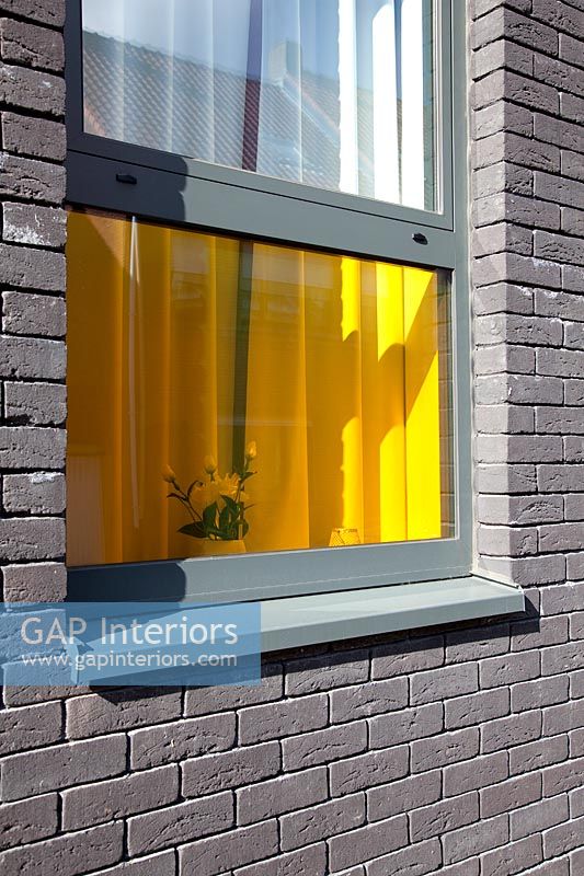 Bâtiment en brique grise avec des fenêtres en verre coloré