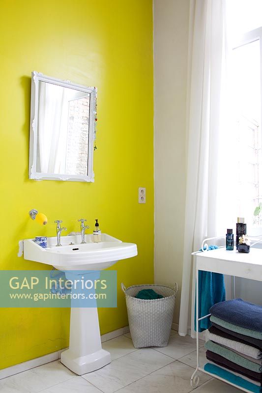Mur caractéristique peint en jaune vif derrière l'évier de la salle de bain