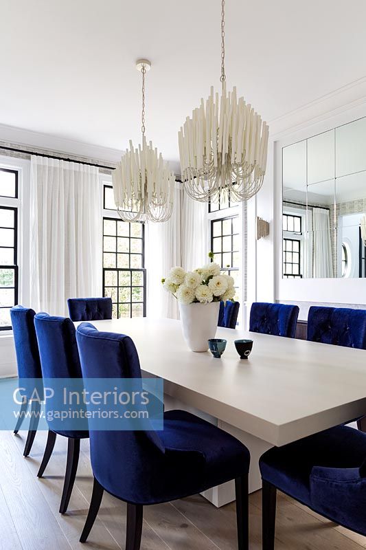 Salle à manger noir et blanc avec des chaises rembourrées bleues