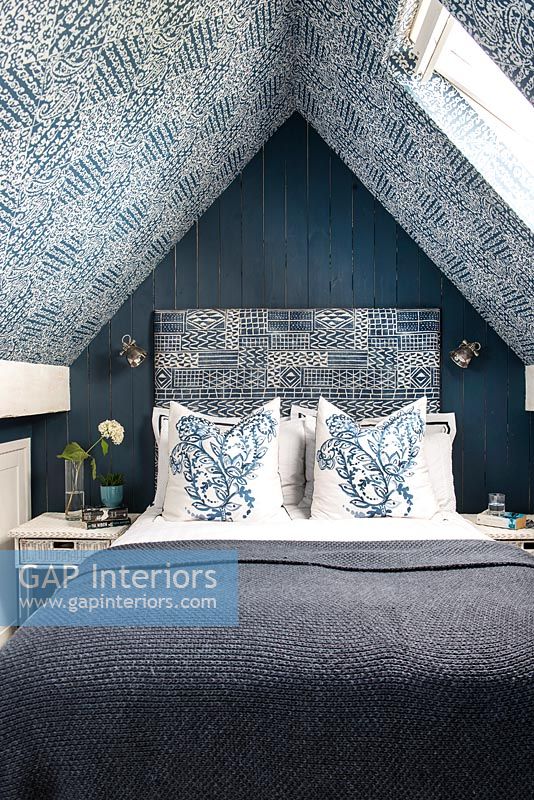 Chambre moderne avec papier peint à motifs bleus et tête de lit assortie