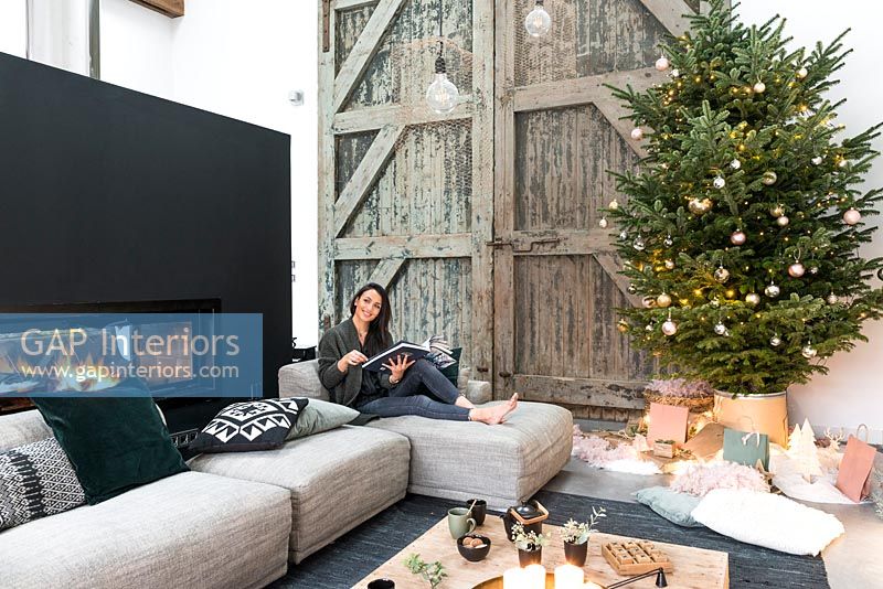Femme détente dans un salon de campagne moderne décoré pour Noël