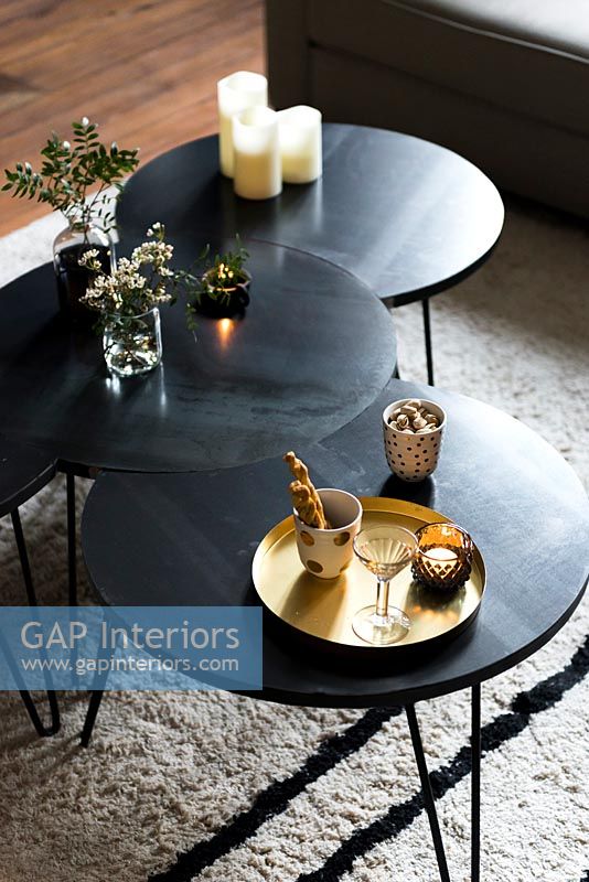 Tables basses modernes noires avec thé et biscuits et bougies