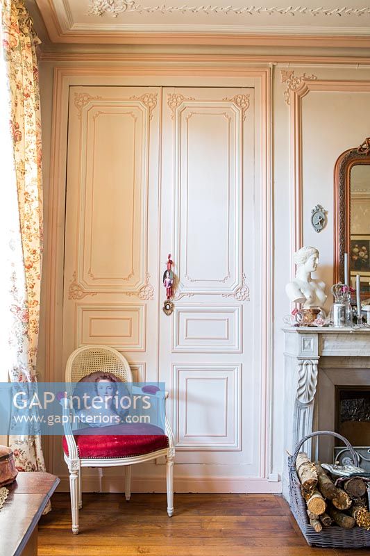 Portes lambrissées peintes en rose dans le salon classique