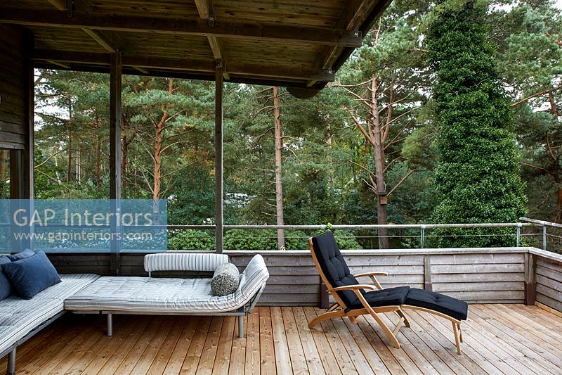 Fauteuils inclinables et canapé sur balcon en bois
