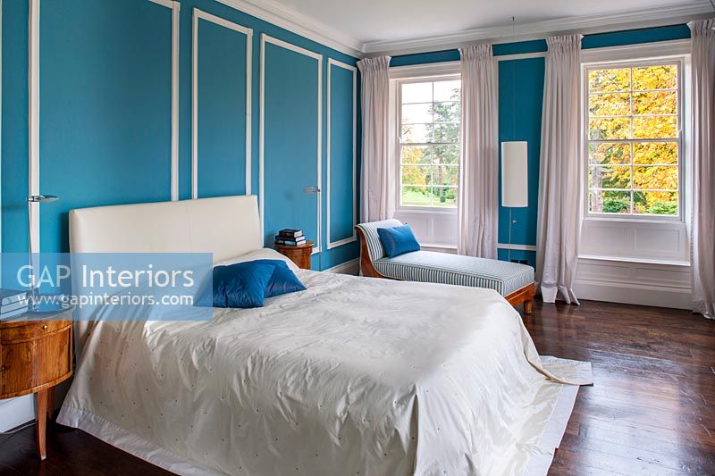 Chambre classique avec murs lambrissés peints en bleu