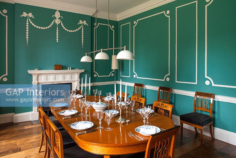 Salle à manger classique avec des murs lambrissés verts et blancs