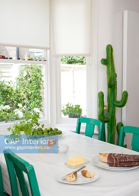 Cactus jouet à côté de la table à manger verte et blanche
