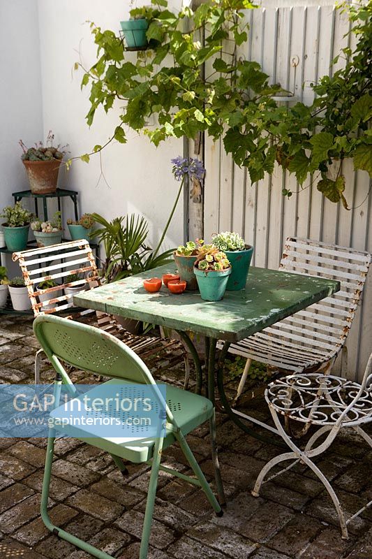Petite table de café verte et chaises sur terrasse