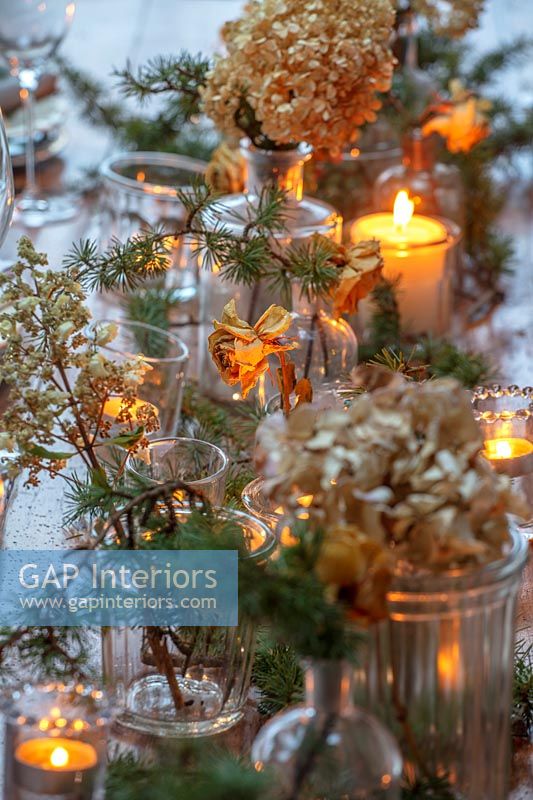 Fleurs séchées dans des vases sur la table à manger de Noël avec des bougies