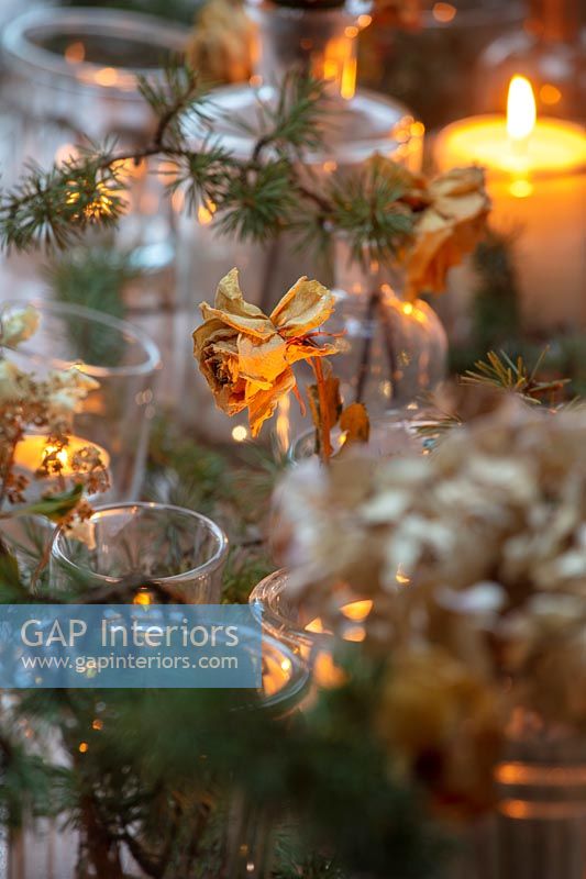 Fleurs séchées dans des vases et des bougies sur la table à manger de Noël