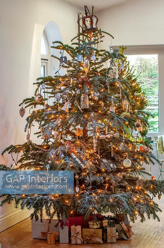 Grand arbre de Noël décoré avec des guirlandes et des cadeaux