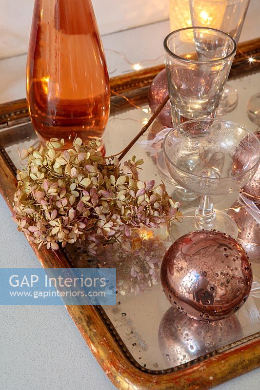 Décorations en bronze et or sur plateau avec verres et fleur d'hortensia séchée