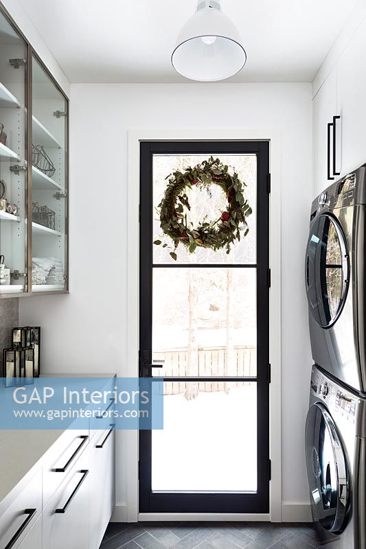 Couronne de Noël sur porte en verre encadrée noire dans la cuisine moderne
