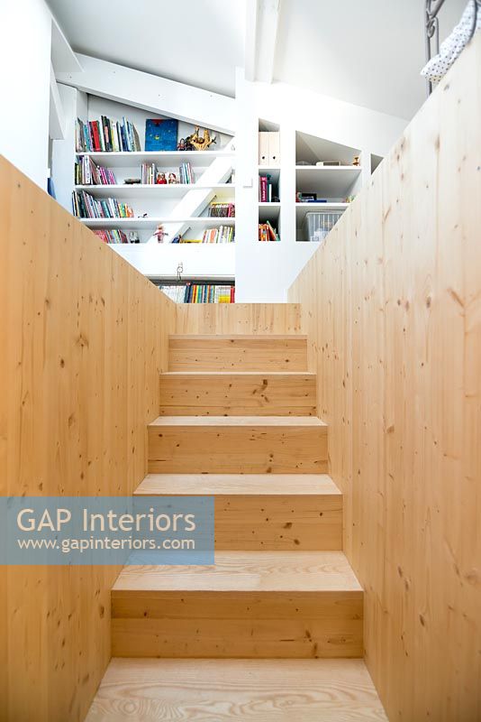 Escalier en bois avec vue sur les étagères intégrées dans la chambre à l'étage