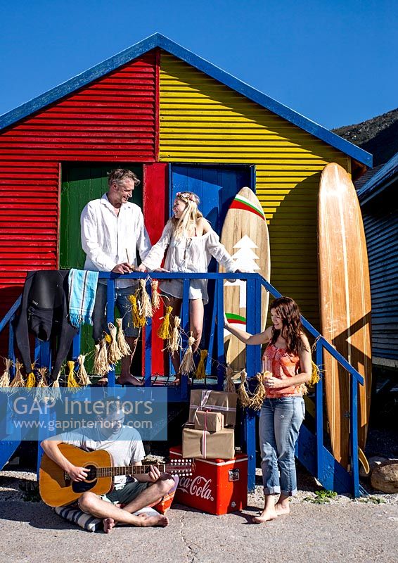 Famille à l'extérieur des cabines de plage colorées