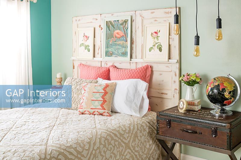 Tête de lit en bois vieilli avec des peintures dans une chambre éclectique
