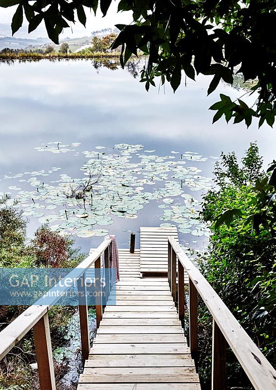 Escalier en bois menant à une petite jetée et un lac