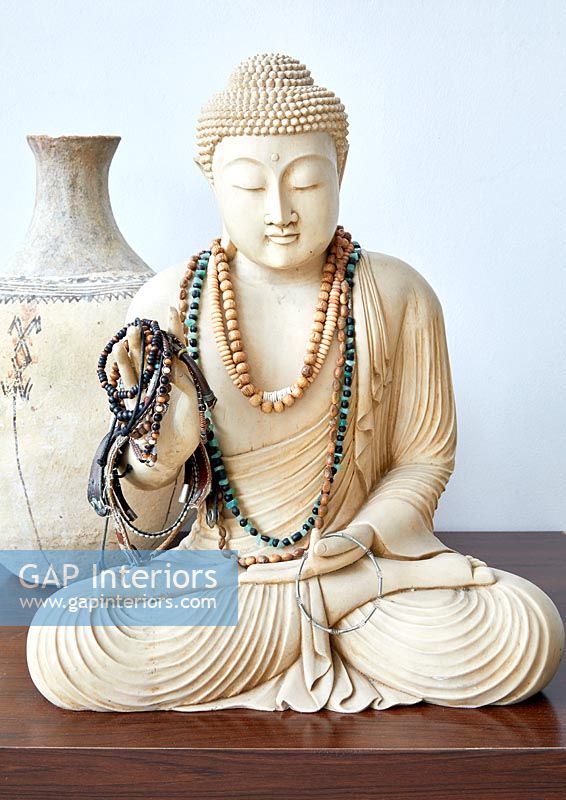 Statuette de Bouddha recouverte de colliers et bracelets en perles