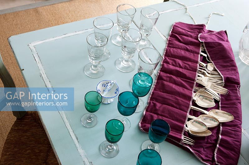 Couverts et verrerie en argent antique sur table à manger bleu pâle