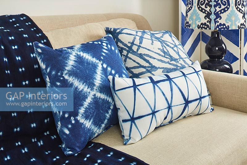 Divers coussins bleus et blancs sur canapé