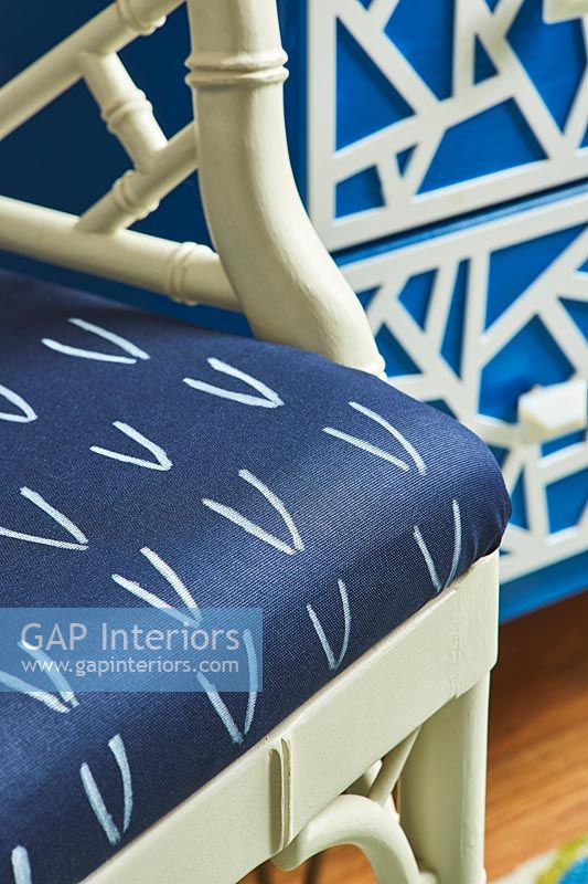 Coussin à motifs bleu et blanc sur chaise en bois peint