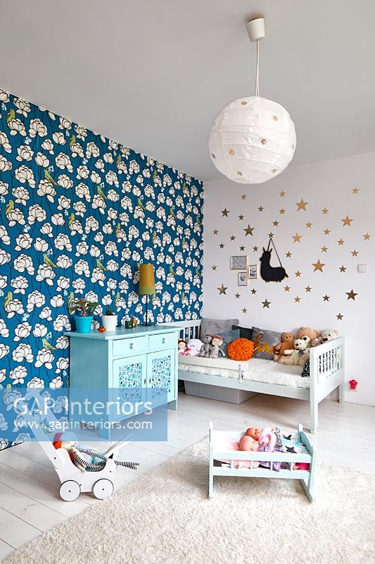 Chambre pour enfants avec papier peint imprimé audacieux sur mur caractéristique