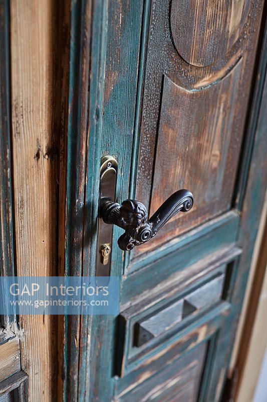 Porte peinte vieillie avec poignée de porte en fer classique
