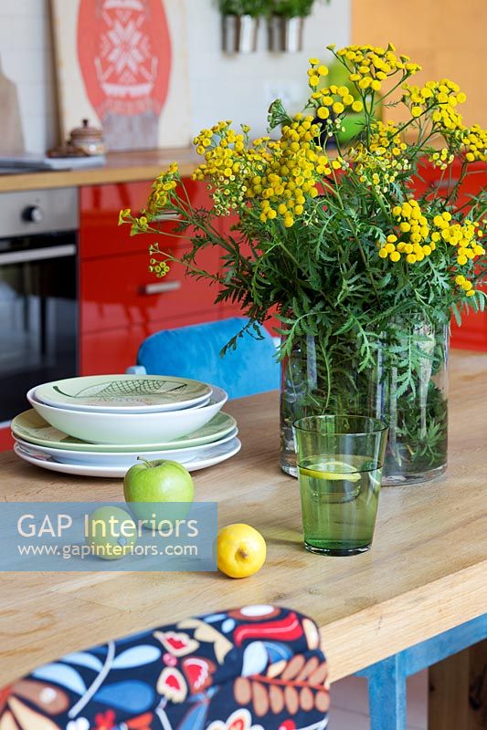Fleurs, fruits et verre sur table en cuisine-salle à manger