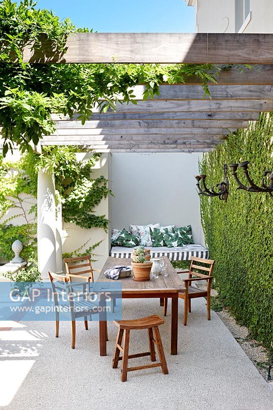 Table et chaises de jardin sur terrasse avec mur vivant