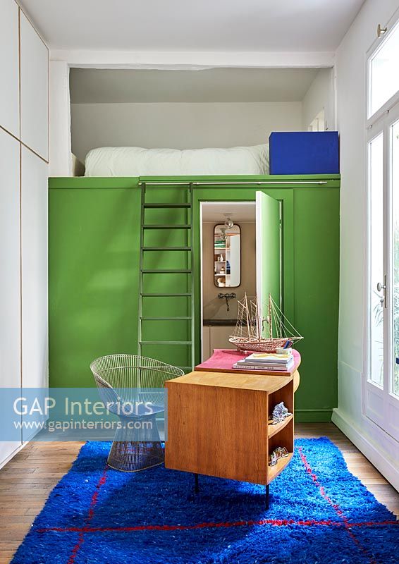 Bureau à domicile moderne avec mur peint et échelle pour se coucher sur une petite mezzanine