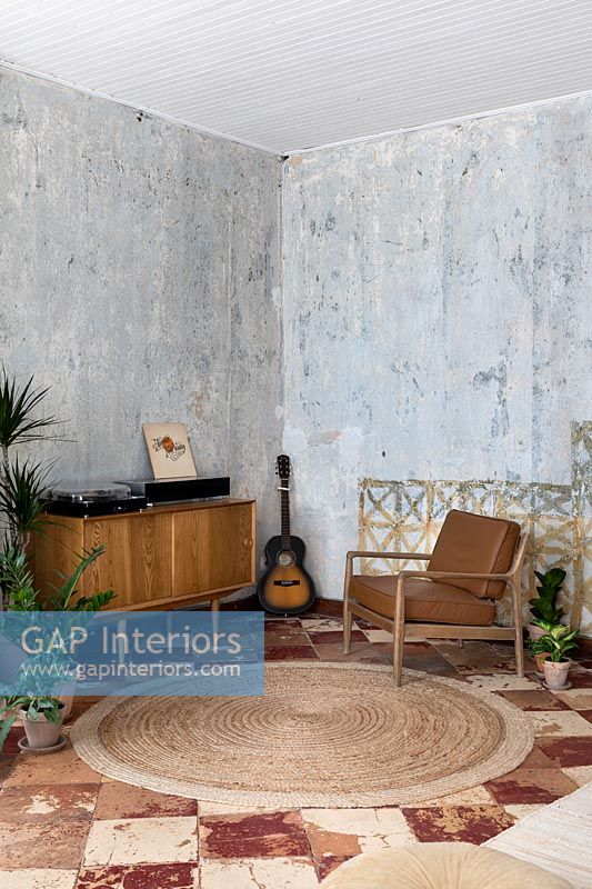 Salon avec mobilier vintage et murs en plâtre nu