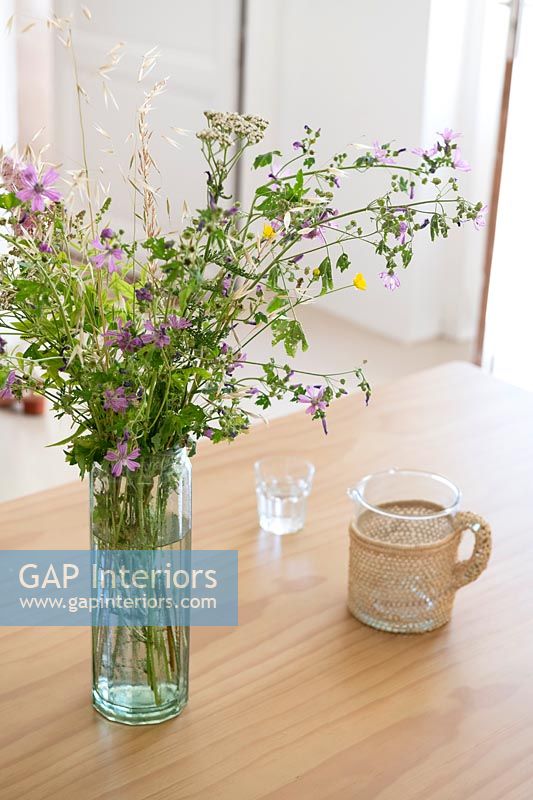 Détail d'arrangement de fleurs sauvages dans un vase sur une table en bois