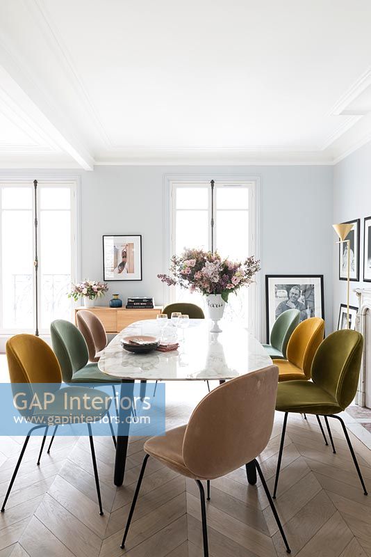 Chaises rembourrées de différentes couleurs autour de la table à manger en marbre vintage