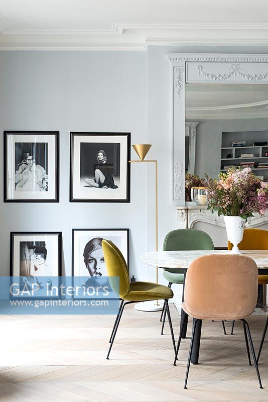 Photographies en noir et blanc encadrées dans la salle à manger avec des meubles vintage