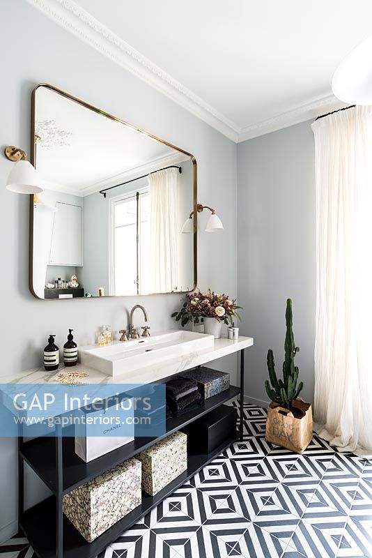 Grand miroir sur lavabo en marbre dans la salle de bain monochrome