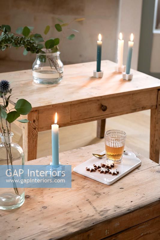 Bougies sur des tables en bois avec boisson et biscuits de Noël