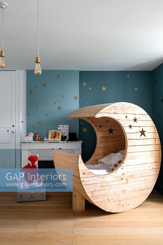 Lit bébé en forme de lune en bois dans la chambre d'enfant moderne
