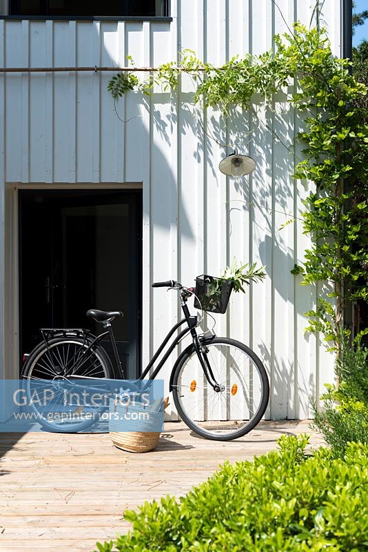 Vélo et panier par porte d'entrée de maison de campagne moderne
