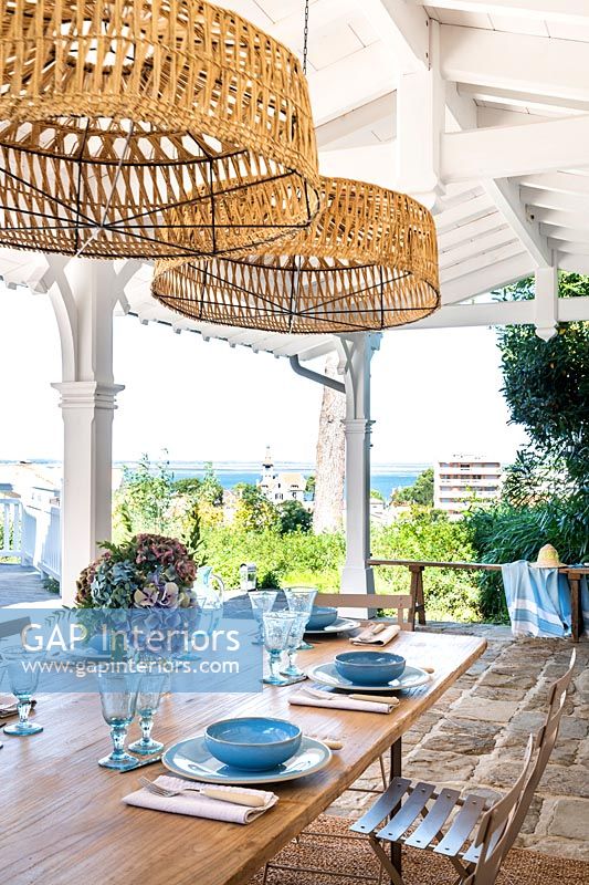 Coin repas extérieur sur terrasse couverte avec vue mer