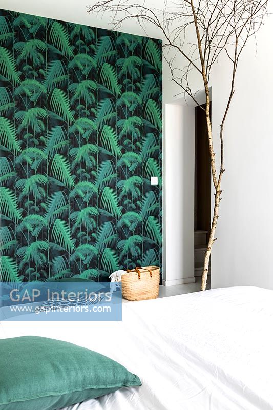 Mur en papier peint vert et ornement de branche d'arbre nu dans une chambre moderne