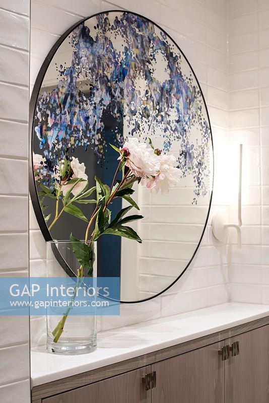 Miroir peint décoratif et fleurs dans la salle de bain