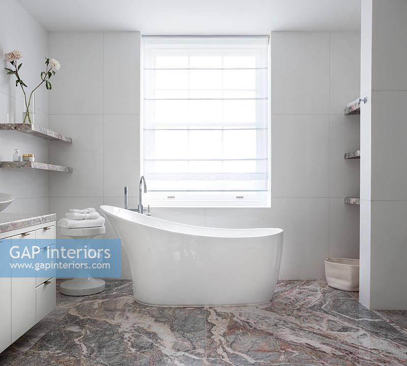 Bain autoportant dans la salle de bain moderne avec sol en marbre