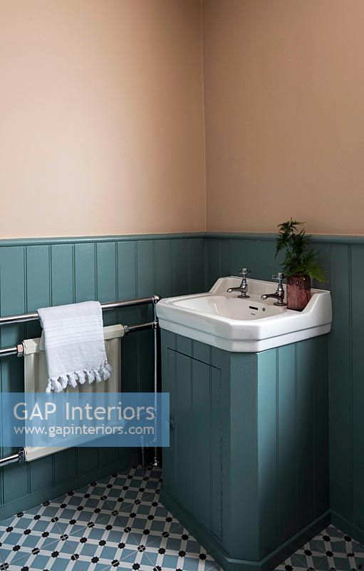 Meuble-lavabo blanc dans salle de bain lambrissée en bois peint bleu